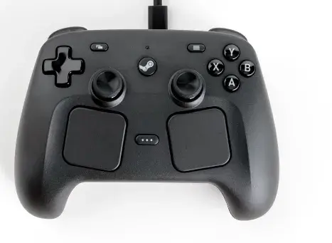 Valve Announces New Steam Machine, Steam Controller and Steam Frame for release in 2026. There is an image of a Steam Controller, which looks like a hybrid between the original Steam Controller and the layout and trackpads of the Steam Deck.